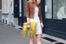 With white top, brown suede jacket, beige mini skirt and flat shoes