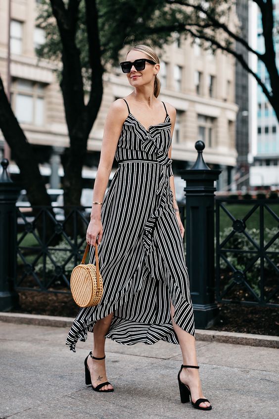 a beautiful black and white wrap ruffle midi dress on straps, black block heels, a round wicker bag for summer