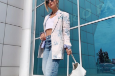 a bold look with blue baggy jeans, a white crop top, a floral oversized blazer and a white bag
