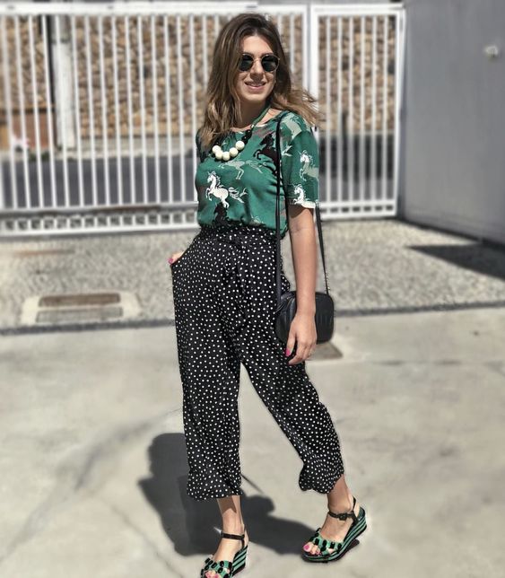 a bright look with a green printed tee, black polka dot cropped pants, green and black sandals and a black bag