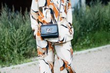 a bright oversized pajama suit, a black crossbody and black slipons for a bold look