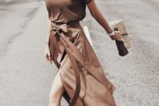 a brown t-shirt, a matching asymmetrical midi skirt, white sneakers and a hat
