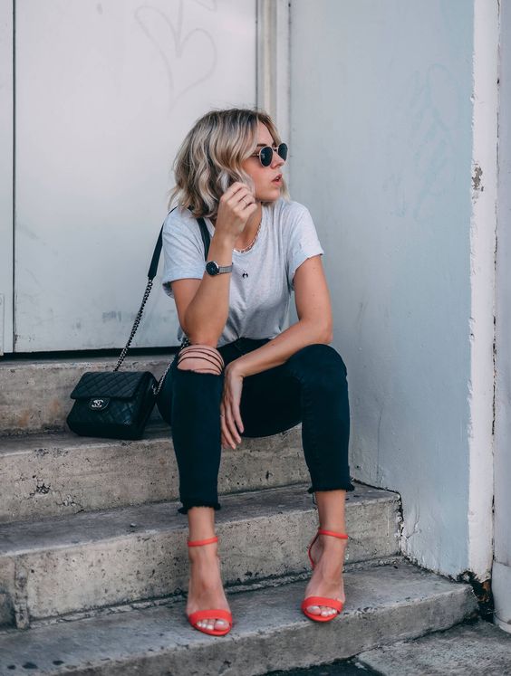 a casual look with a grey tee, black ripped skinnies, a black crossbody and orange minimalist heels for a touch of color