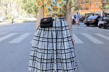 a chic outfit with a bright sunflower print crop shirt, a plaid full skirt, two tone heels and a black bag