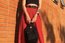 a contrasting look with a black bra crop top, red high waisted wideleg pants, black sneakers and a backpack