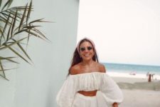 a cool vacation suit with an off the shoulder crop top with long sleeves and wideleg pants plus a wicker bag