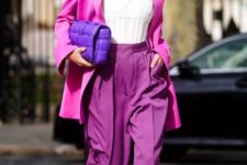 a hot pink blazer, purple pants, a white top, a hot purple bag and white square toe shoes