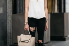 a monochromatic outfit with a white spaghetti strap top, black ripped jeans, tan minimalist heels and a neutrla tote