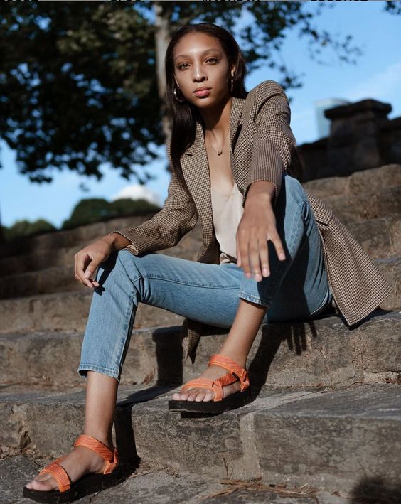 a neutral tank top, blue cropped jeans, a plaid blazer, orange sporty sandals for a colorful accent