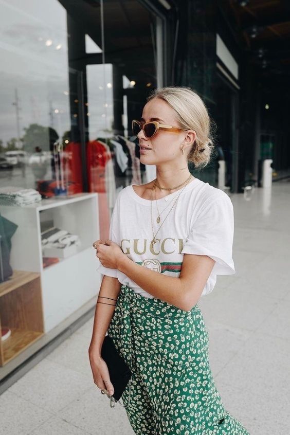 a printed tee, a green wrap floral skirt and layered necklaces for a summer feel in your look