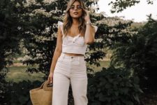 a retro-inspired crop top with ruffle shoulders, white straight jeans, white strappy shoes and a wicker bag