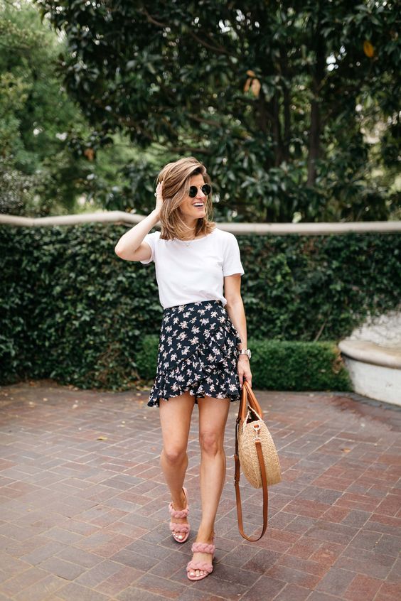 a romantic look with a white tee, a black floral wrap mini skirt, pink braided heels and a wicker bag