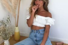 a sexy boho look with a white lace off the shoulder crop top and high waisted blue jeans