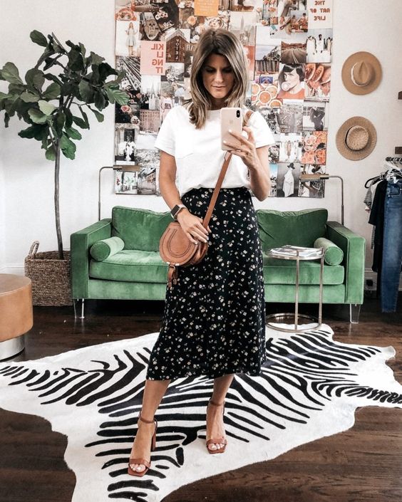 a stylish look with a white tee, a black floral midi skirt, brown block heels and a bag