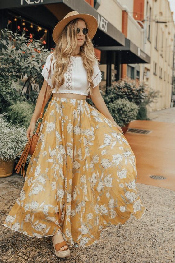 a white boho lace crop top, a yellow floral maxi A-line skirt, a hat, a brown bag and platform shoes