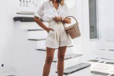 a white oversized shirt with short sleeves, neutral paperbag shorts, neutral mules and a basket