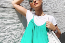 a white tee, a bright green dress over it and pastel green cat-eye sunglasses for accenting the dress