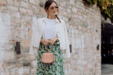 a white tee, a green floral wrap skirt, a white denim jacket, white sneakers and a blush bag