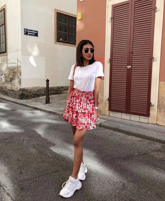 a white tee, a pink floral ruffle mini skirt, white trainers and layered necklaces