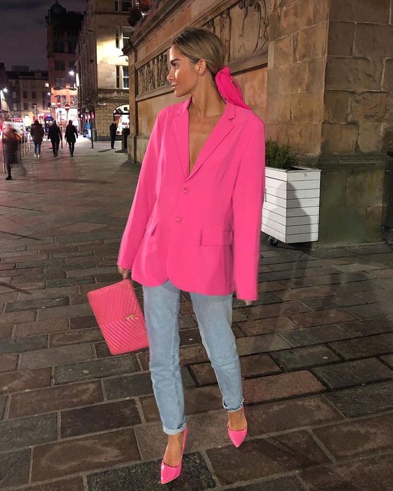 an oversized hot pink blazer, blue mom jeans, hot pink shoes and a small clutch