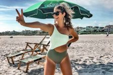 11 a bold one piece one shoulder cutout swimsuit with a white top and a green bottom