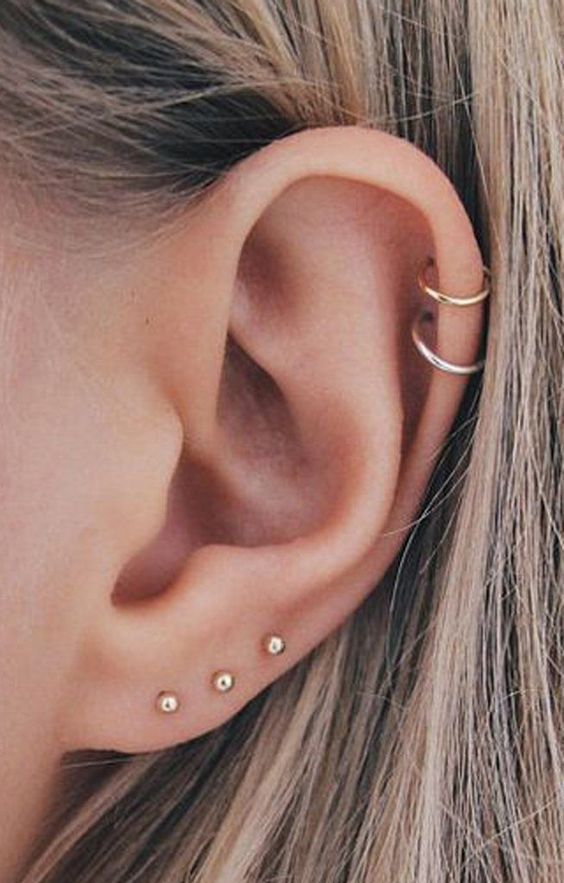 gold studs in the lobe and matching gold hoop earrings for a double helix piercing