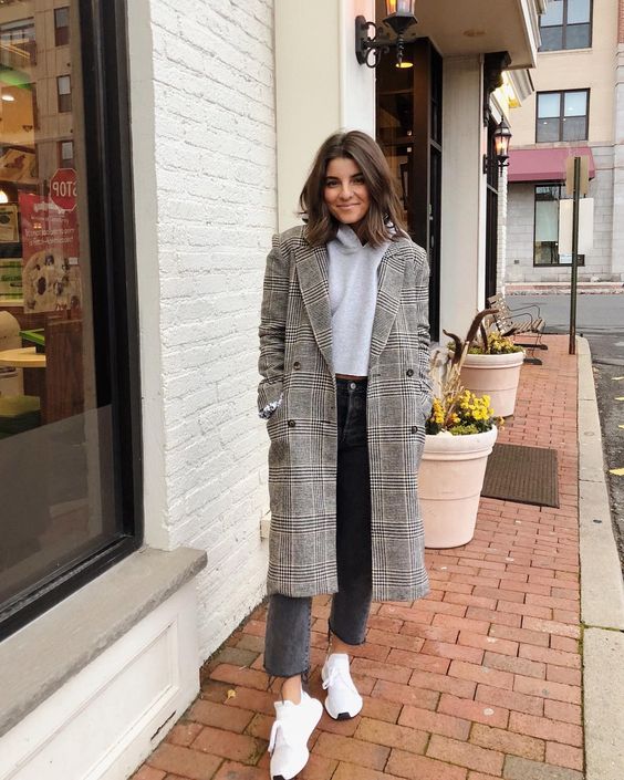 a comfy outfit with a grey crop top, black cropped jeans, white trainers and a grey plaid coat