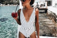 27 a chic striped one piece black and white swimsuit with a plunging neckline, ties and a boho necklace