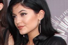 Kylie Jenner rocking 9 stacked helix piercings with matching hoop earrings and a statement long one