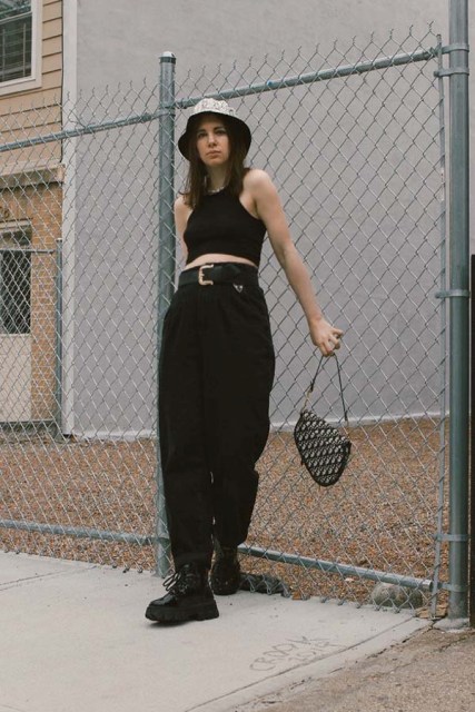 With black crop top, loose trousers, printed bag and lace up boots