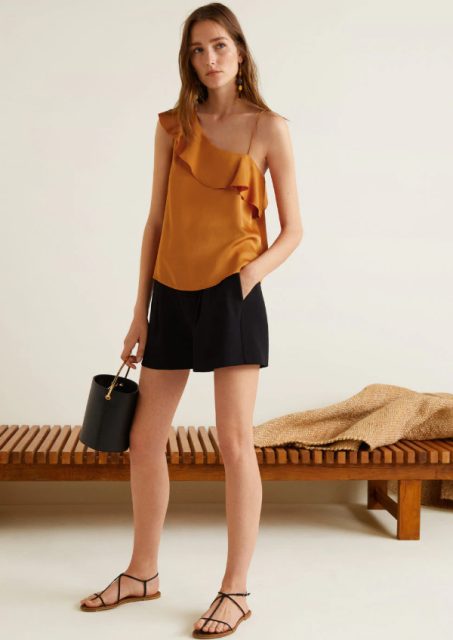 With black shorts, black bag and flat sandals