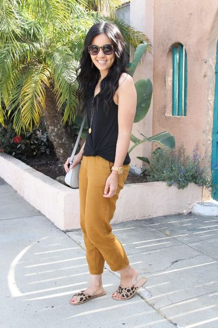 With black sleeveless top, gray bag and yellow cropped pants