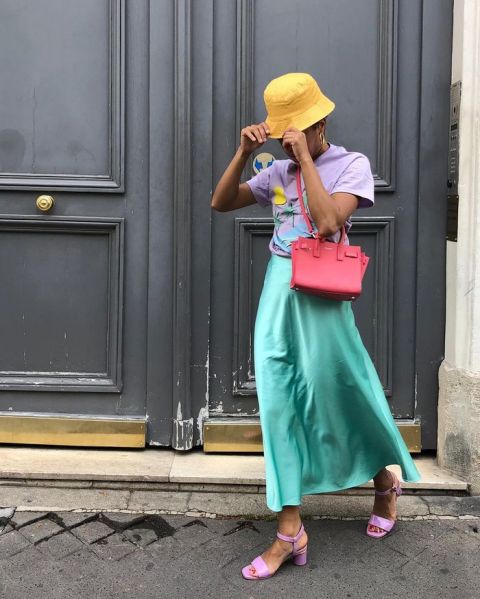 With lilac t-shirt, green skirt, red bag and lilac shoes