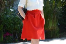 With red knee-length skirt, chain strap bag and red and black shoes