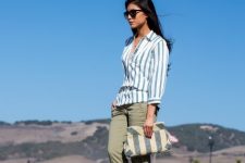 With striped shirt, olive green pants and ankle boots