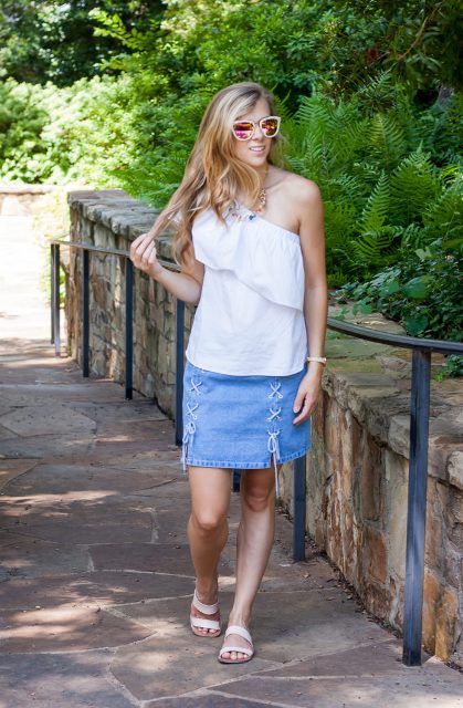 With white one shoulder ruffled top and white flat sandals