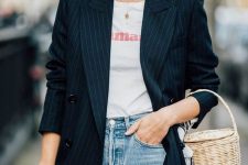 a casual outfit with a printed tee, blue jeans, a thin stripe blazer and a basket bag plus sunglasses
