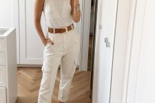 a glam outfit with a white halter top, white cargo pants, tan heels and a brown leather belt plus statement earrings