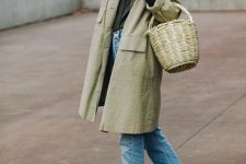 a green shirt, blue jeans, a green trench and black vintage-inspired shoes plus a basket