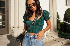 a grunge yet romantic outfit with blue jeans, a plaid emerald crop top with puff sleeves and a black bag