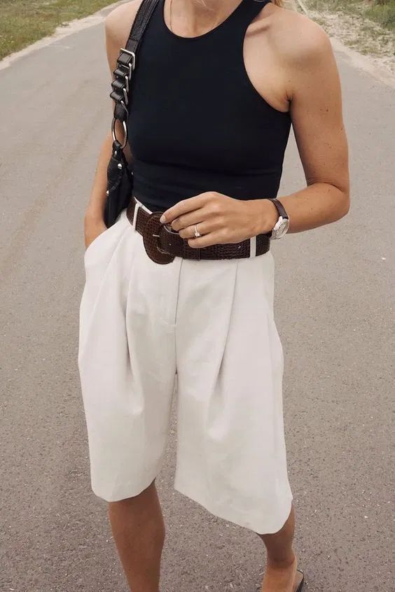 a monochromatic work look with a black halter top, white Bermuda shorts, a black bag and slippers