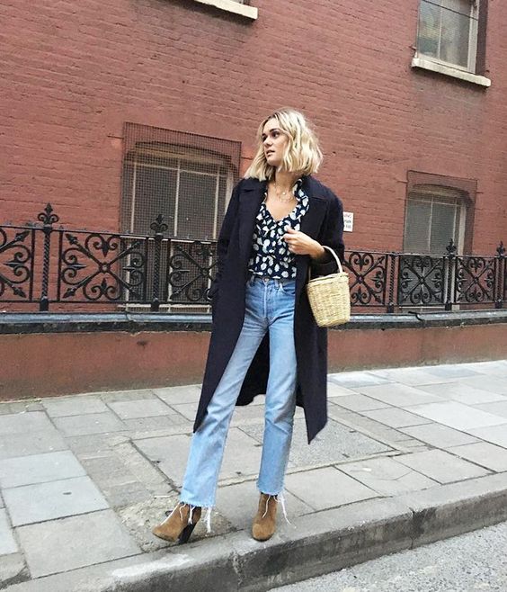 a printed shirt, blue jeans, tan velvet booties, a navy midi coat and a basket bag