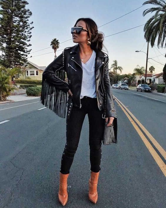 a rock-inspired look with a white tee, black jeans, amber booties, a black leather fringe jacket