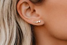 a small yet chic rhinestone and gold ear climber is a nice solution for a modern outfit