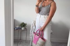 a striped black and white top, white jeans, black daddy sandals and a hot pink raffia bag plus pink sunglasses