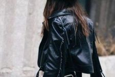a total black look with a cropped leather fringe jacket, a hat and a statement chic bag