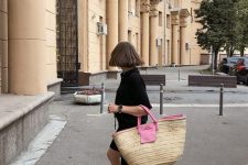 a total black look with a short sleeved shirt and Bermuda shorts, black slippers and a hot pink raffia bag