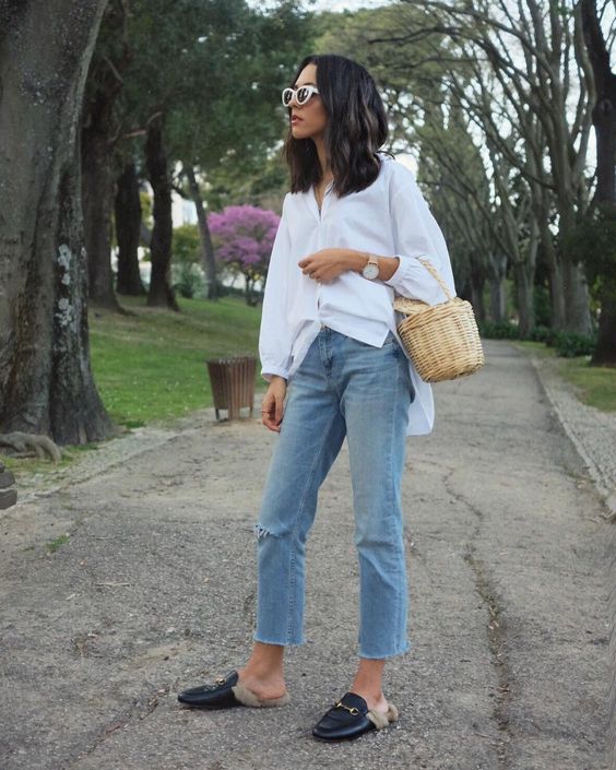 a white oversized shirt, blue jeans, black fur mules and a basket bag for a summer to fall transition
