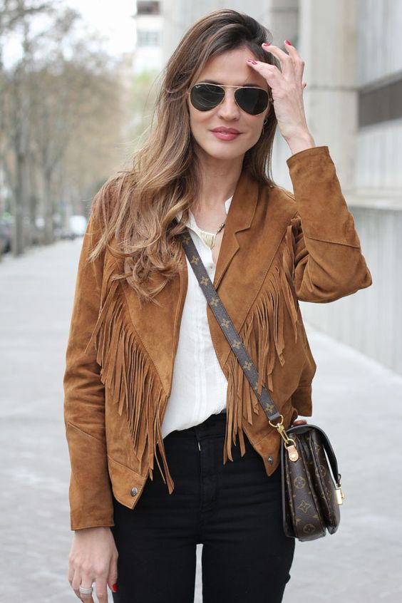 a white shirt, black jeans and a rust-colored fringe leather jacket plus a crossbody bag for fall