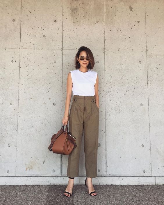 a white sleeveless top, green high waisted pants, black shoes and a brown bag for a minimal look